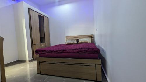 a bedroom with a bed with a purple comforter at Nexcon Apartments in Uyo