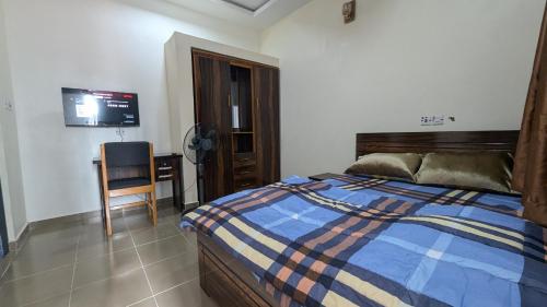 a bedroom with a bed and a desk and a television at Nexcon Apartments in Uyo
