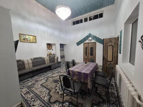 a room with a table and chairs and a couch at Polyoz Ota in Khiva