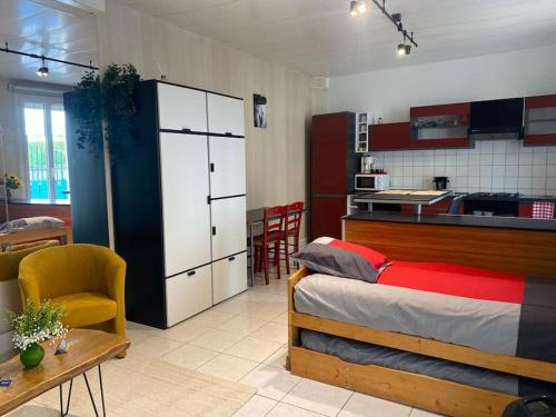 a bedroom with a bed and a kitchen and a table at Les Galipes in Avize