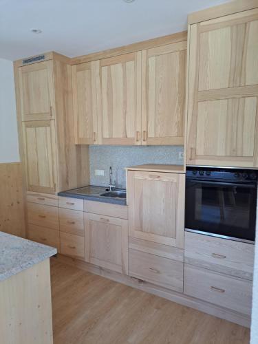 an empty kitchen with wooden cabinets and a sink at Ferienhof Brunbacher Wolfgangsee in St. Wolfgang