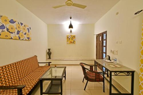 a living room with a couch and a table at Poppys Olive de' villa in Auroville