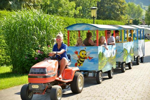 a group of people riding on a small train at Woferlgut - Wellness & Sport in Bruck an der Großglocknerstraße