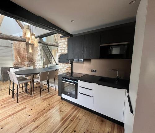 une cuisine avec une table et une salle à manger dans l'établissement Détente parfaite Gîte Le Centre Jacuzzi Sauna, à Montreuil-sur-Mer