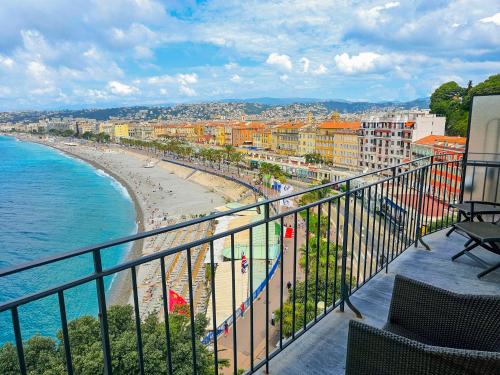 a balcony with a view of a beach and the ocean at Hôtel La Pérouse Nice Baie des Anges in Nice