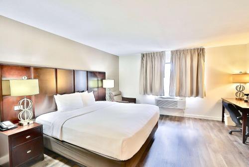 a hotel room with a large bed and a desk at Baymont by Wyndham Tucson Airport in Tucson