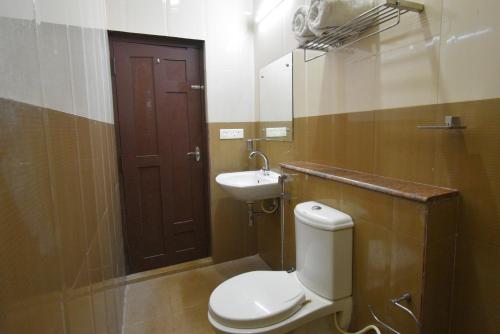 a bathroom with a toilet and a sink at Poppys Olive de' villa in Auroville