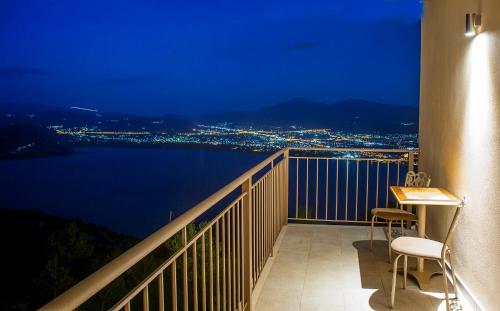 a balcony with a view of the water at night at Arktos Hotel in Ioannina