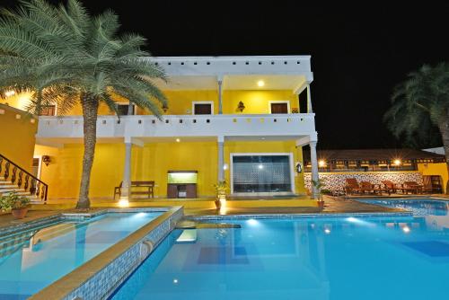 a villa with a swimming pool at night at Poppys Olive de' villa in Auroville