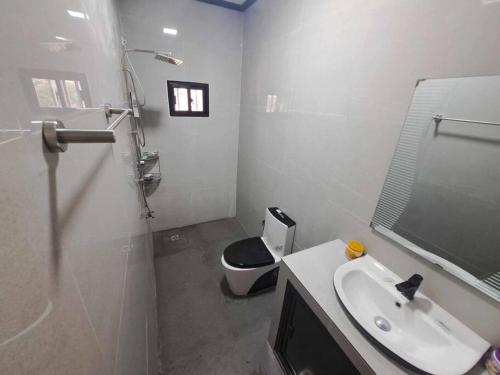 a white bathroom with a toilet and a sink at Anas Sweet Home w Wifi, Karaoke n Free Parking in Alfonso