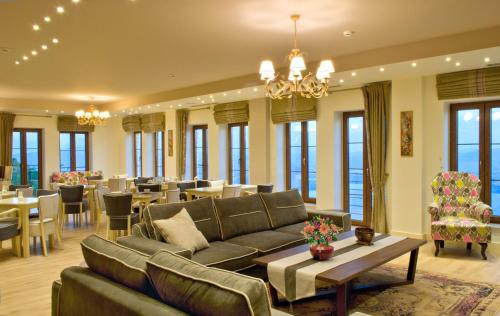 a living room with a couch and tables and chairs at Arktos Hotel in Ioannina