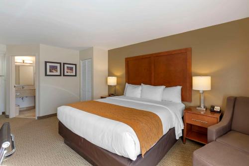 a hotel room with a large bed and a couch at Comfort Inn Kennesaw in Kennesaw