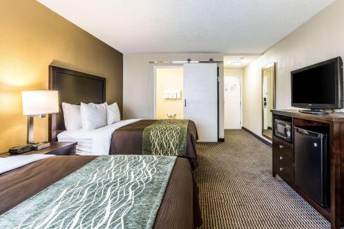 a hotel room with two beds and a flat screen tv at Comfort Inn Detroit Downtown in Detroit