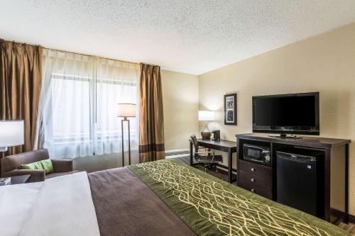 a hotel room with a bed and a flat screen tv at Comfort Inn Detroit Downtown in Detroit