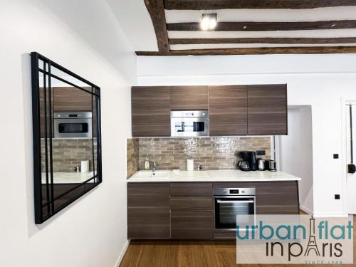 - une cuisine avec des placards en bois et un miroir dans l'établissement Urban Flat 108 - Classic Parisian 4 BDR Flat, à Paris