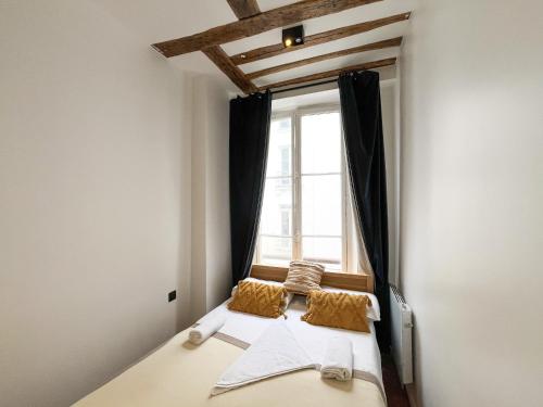 un lit dans une chambre avec une fenêtre dans l'établissement Urban Flat 108 - Classic Parisian 4 BDR Flat, à Paris