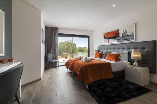 a bedroom with a large bed and a large window at Almancil Elegant Villa With Pool by Homing in Almancil