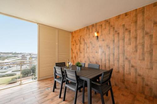 a dining room with a table and chairs and a large window at Lagos Terrace with Pool by Homing in Lagos