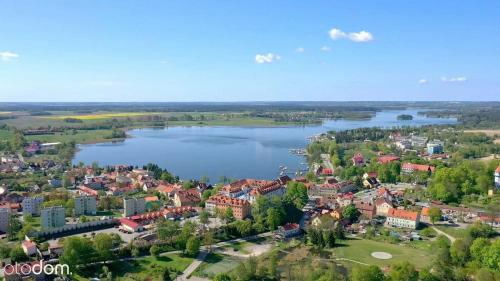 an aerial view of a town next to a lake at Domek Mazury Max nad jeziorem w Rynie in Ryn