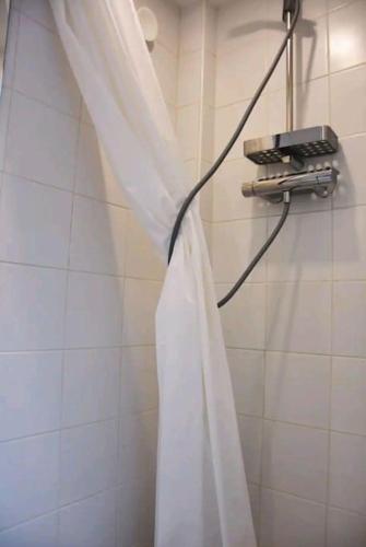 La salle de bains est pourvue d'une douche avec un rideau de douche blanc. dans l'établissement au COEUR de Paris Joli Nid équipé calme clair Ascenseur AC, à Paris