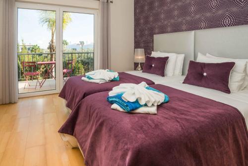 two beds in a hotel room with towels on them at Portimao Elegant House With Pool by Homing in Portimão