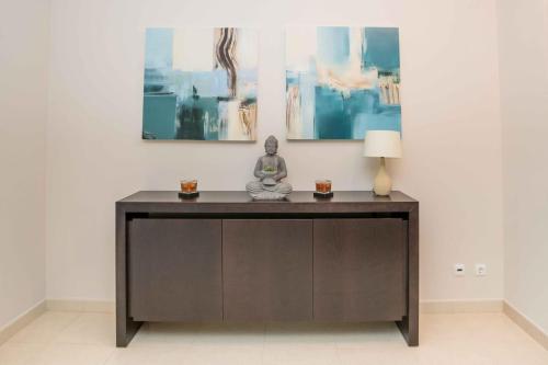 a table with a statue in a room with paintings at Portimao Elegant House With Pool by Homing in Portimão