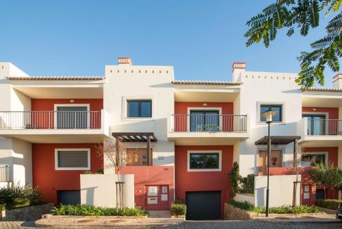 an apartment building with red and white at Portimao Elegant House With Pool by Homing in Portimão