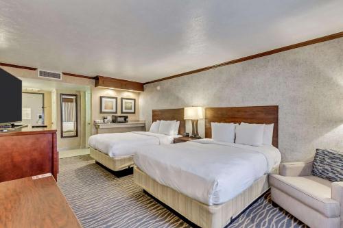 a hotel room with two beds and a couch at Radisson Hotel Salt Lake City Airport in Salt Lake City