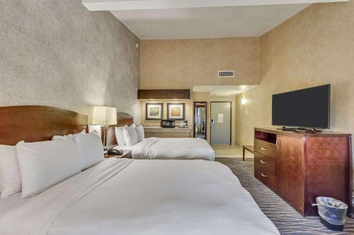 a hotel room with two beds and a flat screen tv at Radisson Hotel Salt Lake City Airport in Salt Lake City