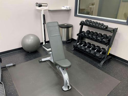a gym with a chair and a rack of weights at Country Inn & Suites by Radisson, Jacksonville West, FL in Jacksonville
