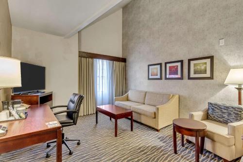 a hotel room with a couch and a desk at Radisson Hotel Salt Lake City Airport in Salt Lake City