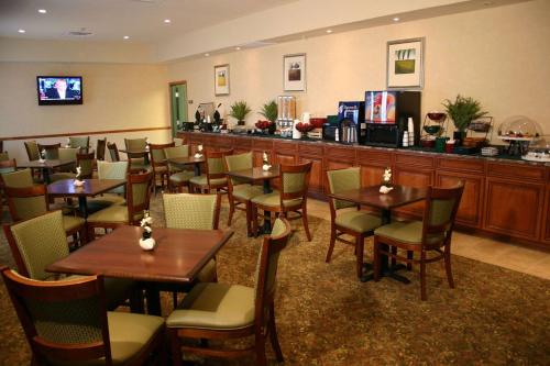 a restaurant with tables and chairs and a bar at Country Inn & Suites by Radisson, Jacksonville West, FL in Jacksonville