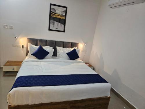 a bedroom with a large bed with blue and white pillows at Pearl Residency in Ayūr