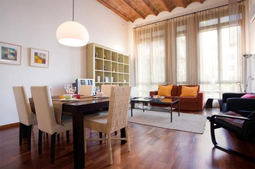 a dining room and living room with a table and chairs at Friendly Rentals Monet in Barcelona