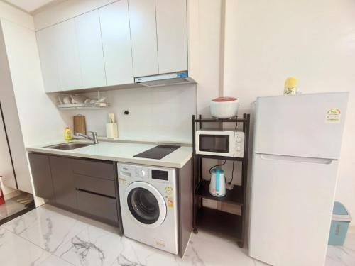 a kitchen with a refrigerator and a washing machine at OYUSTAY Clark Terrace condo Staycation with 2 beds near airport HANN CASINO in Fort Stotsenburg