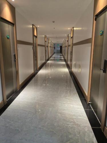 a hallway in a building with doors and a long corridor at OYUSTAY Clark Terrace condo Staycation with 2 beds near airport HANN CASINO in Fort Stotsenburg