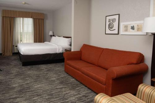 a hotel room with a couch and a bed at Country Inn & Suites by Radisson, BWI Airport Baltimore , MD in Linthicum Heights
