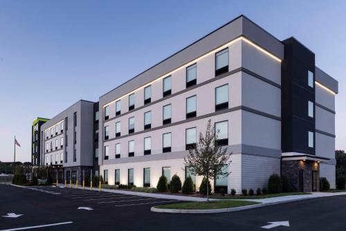 a large white building with a parking lot at Home2 Suites By Hilton East Haven New Haven in East Haven