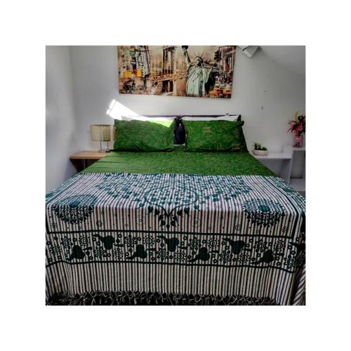 a bedroom with a bed with a green comforter at House of Vecolate in Sowerby Bridge