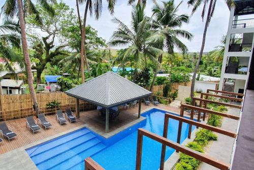 an overhead view of a pool with a gazebo and palm trees at Ramada Suites By Wyndham Seafront Coral Coast in Korotogo