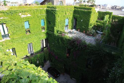 an ivycovered building with a car parked in front of it at Palazzo Rollo in Lecce