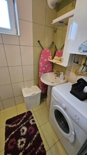 a laundry room with a washing machine and a sink at Sova in Vršac