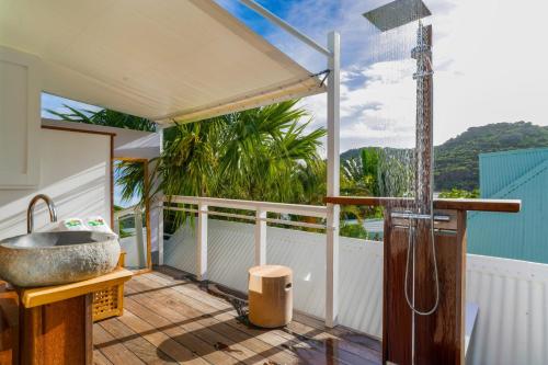 a bathroom with a sink and a shower on a deck at Charming Bungalow in Saint Barthélemy with Shared Pool. in Saint Barthelemy