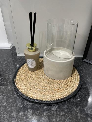 a glass jar and a vase on a table at Luxury 3 Bed House - 10 min walk from Dartford Town Centre - Fully Refurbished in Dartford