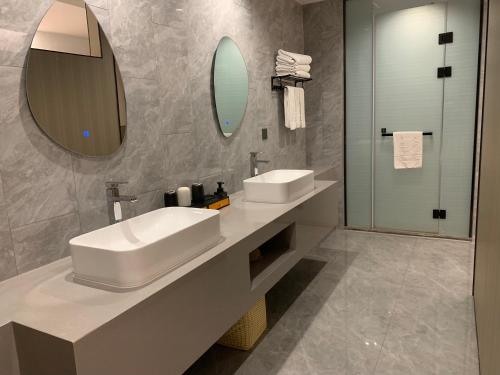 a bathroom with a white sink and a mirror at New Century Mansion Hotel Cixi Guanhaiwei in Cixi