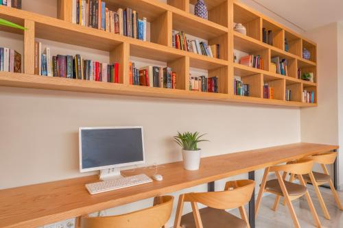 a desk with a computer and some books at Playa Esperanza Resort Affiliated by Meliá in Playa de Muro