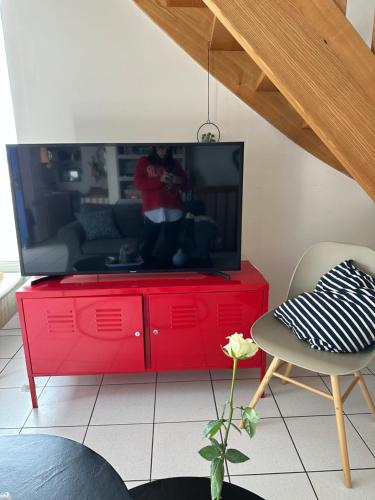 - un centre de divertissement rouge avec une télévision en haut dans l'établissement maison de pêcheurs, à Saint-Michel-en-Grève
