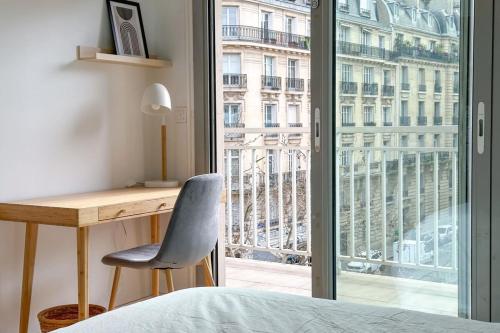 - une chambre avec un bureau et une grande fenêtre dans l'établissement Flexliving - room - Ternes, à Paris