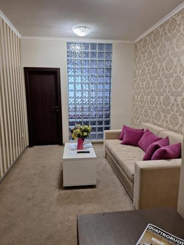 a living room with a couch and a table at Garni Hotel Ema in Kragujevac