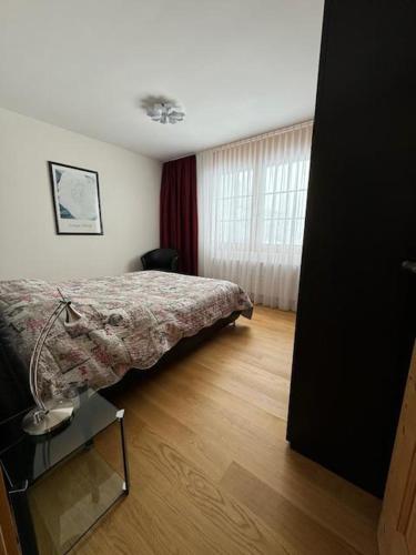 ein Schlafzimmer mit einem Bett und einem Holzboden in der Unterkunft Design Flat Davos in Davos